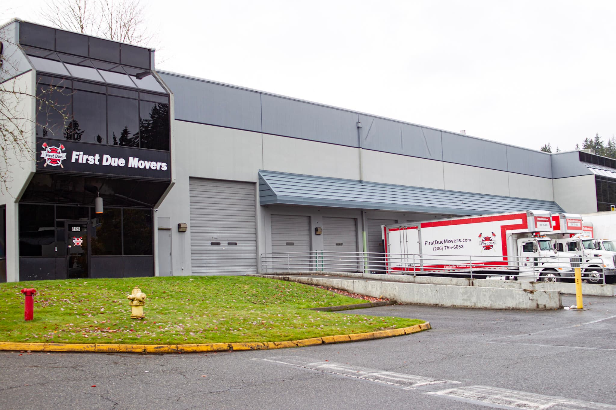 First Due Movers office and warehouse building exterior with company moving trucks parked at the loading dock