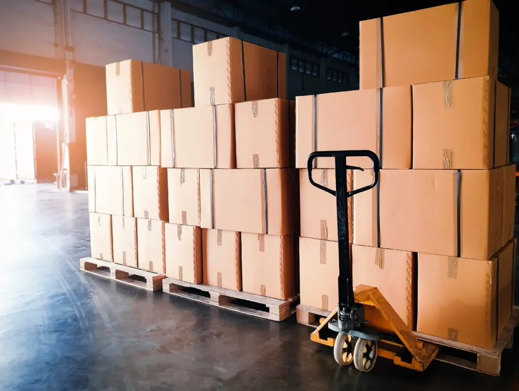 Stack of shipments boxes on wooden pallets at interior warehouse storage