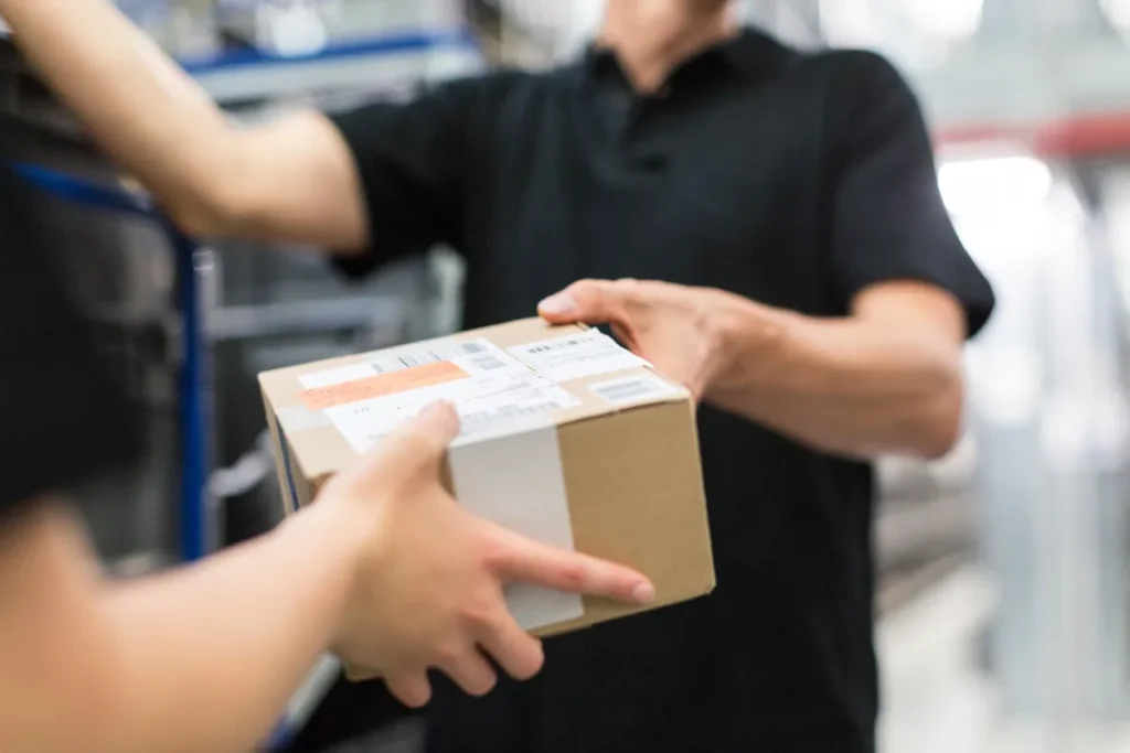 Worker handing over a package to colleague